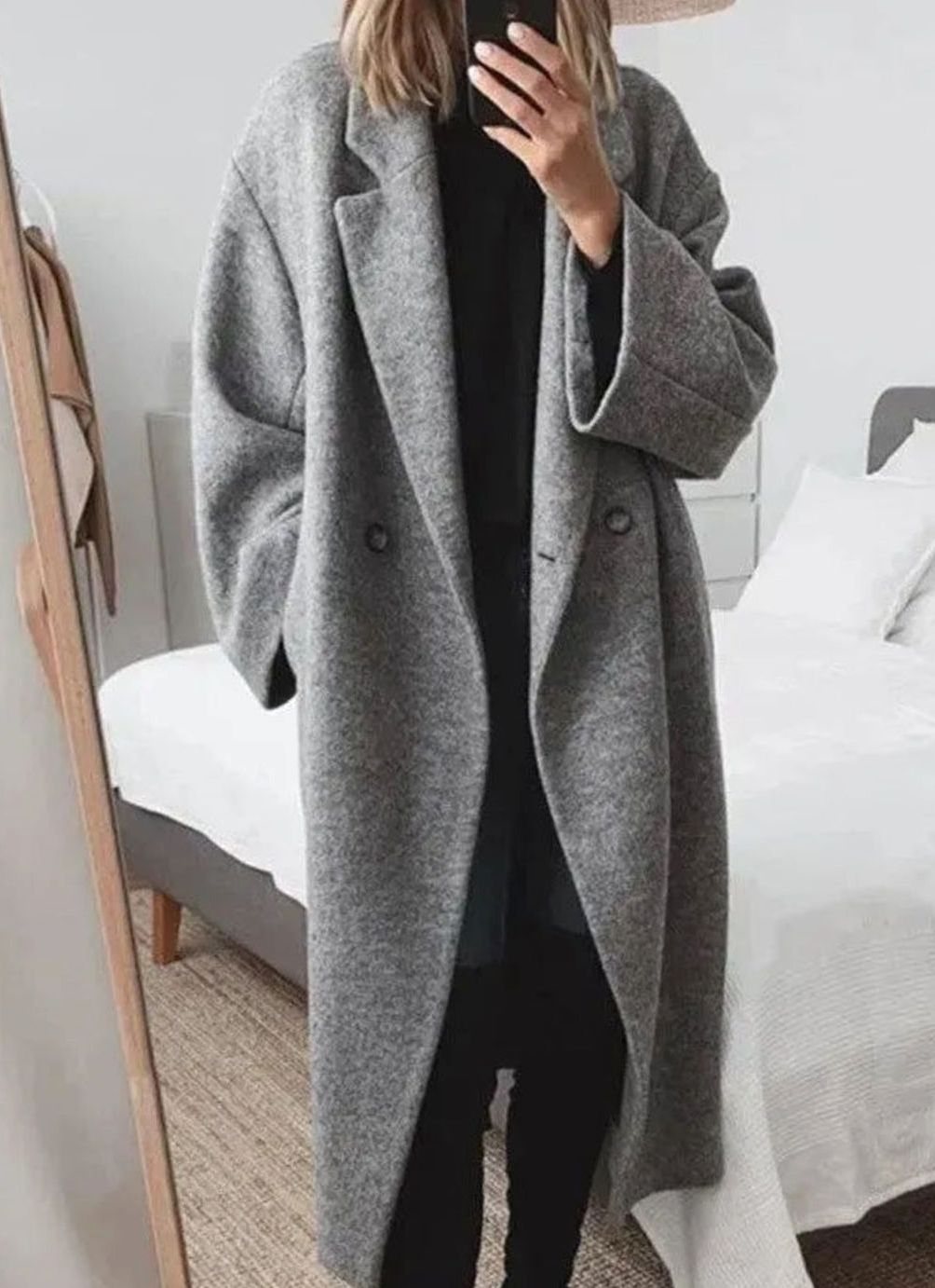 Mujer con abrigo largo oversize cruzado en color gris paseando por la ciudad